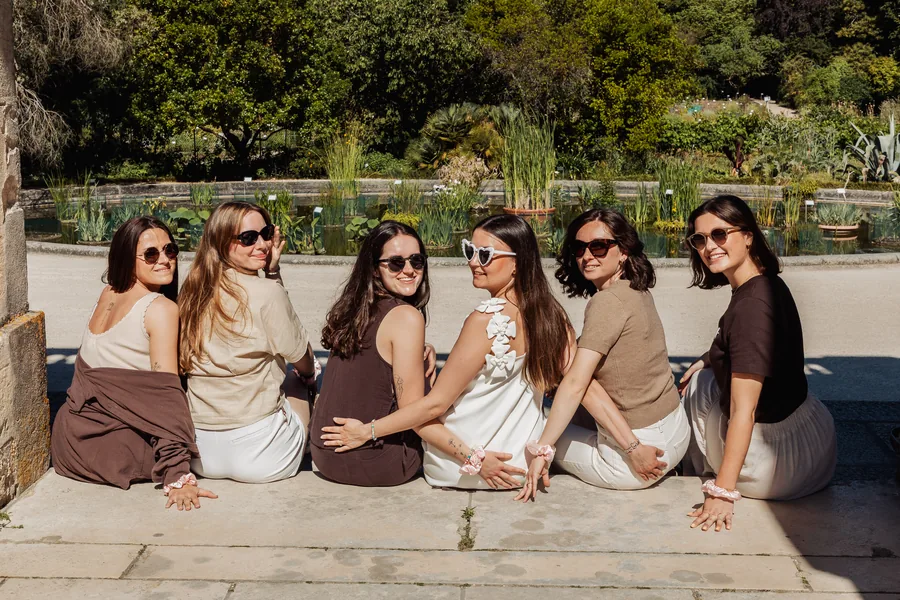 Les copines assises sur un muret de pierre, hautes herbes derrière elles, EVJF à Bordeaux