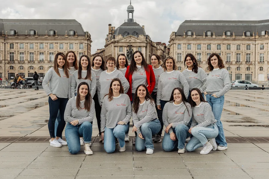 Le groupe au complet devant une grande place, façades classiques derrière, EVJF à Bordeaux