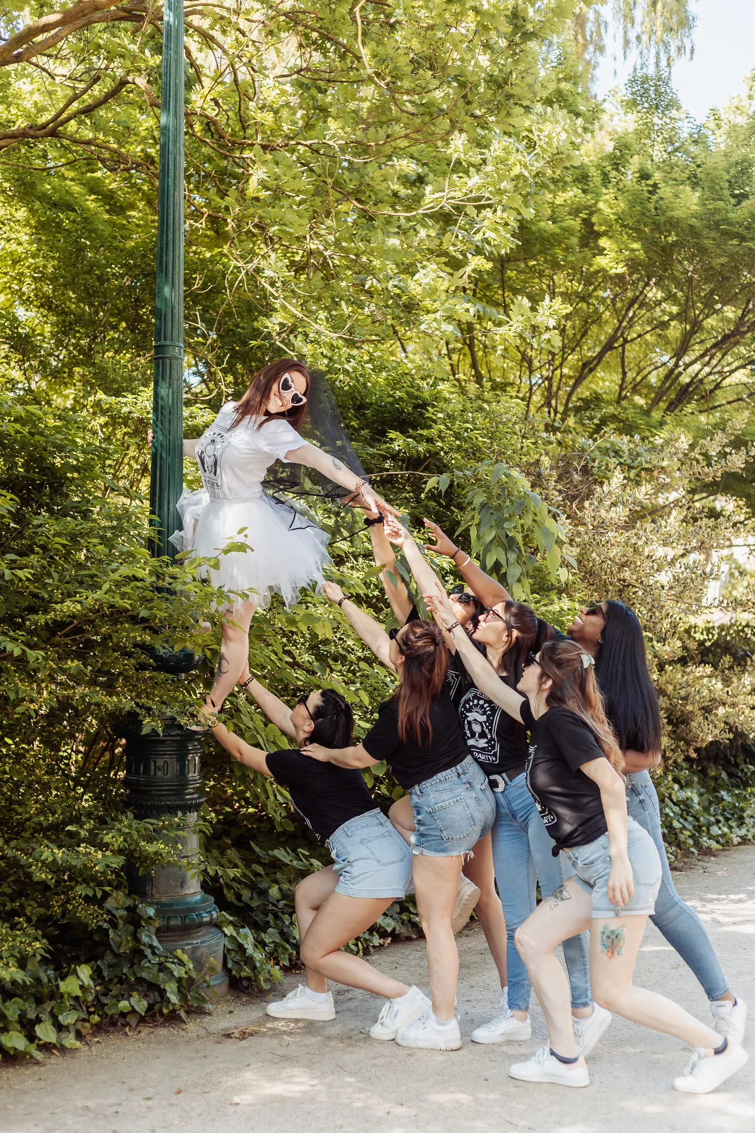 Les copines qui portent la mariée à bout de bras sous un lampadaire, EVJF à Bordeaux