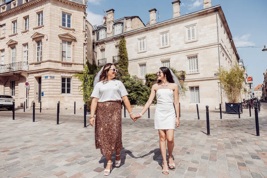 Deux copines main dans la main sur les pavés d'une place bordelaise, EVJF à Bordeaux