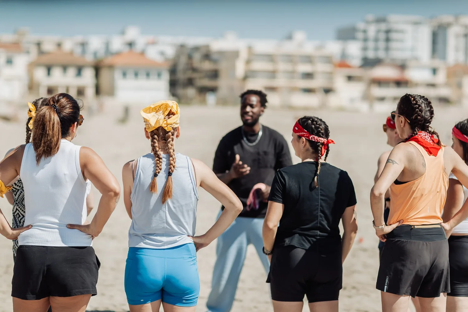 Koh-Bride : l'animateur donne les consignes aux deux équipes, bandanas rouges et jaunes, sur la plage